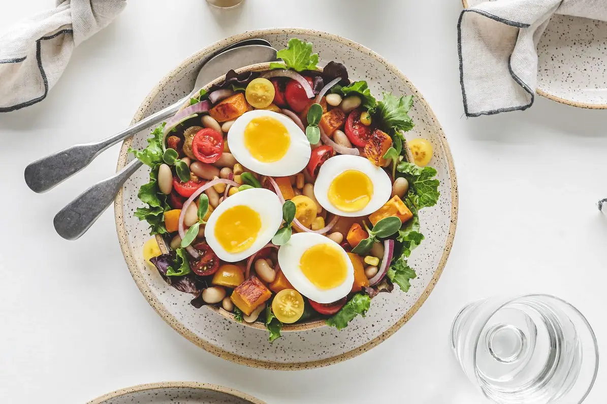 a bowl of salad with eggs and vegetables