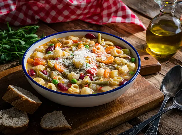 a bowl of soup with pasta and vegetables
