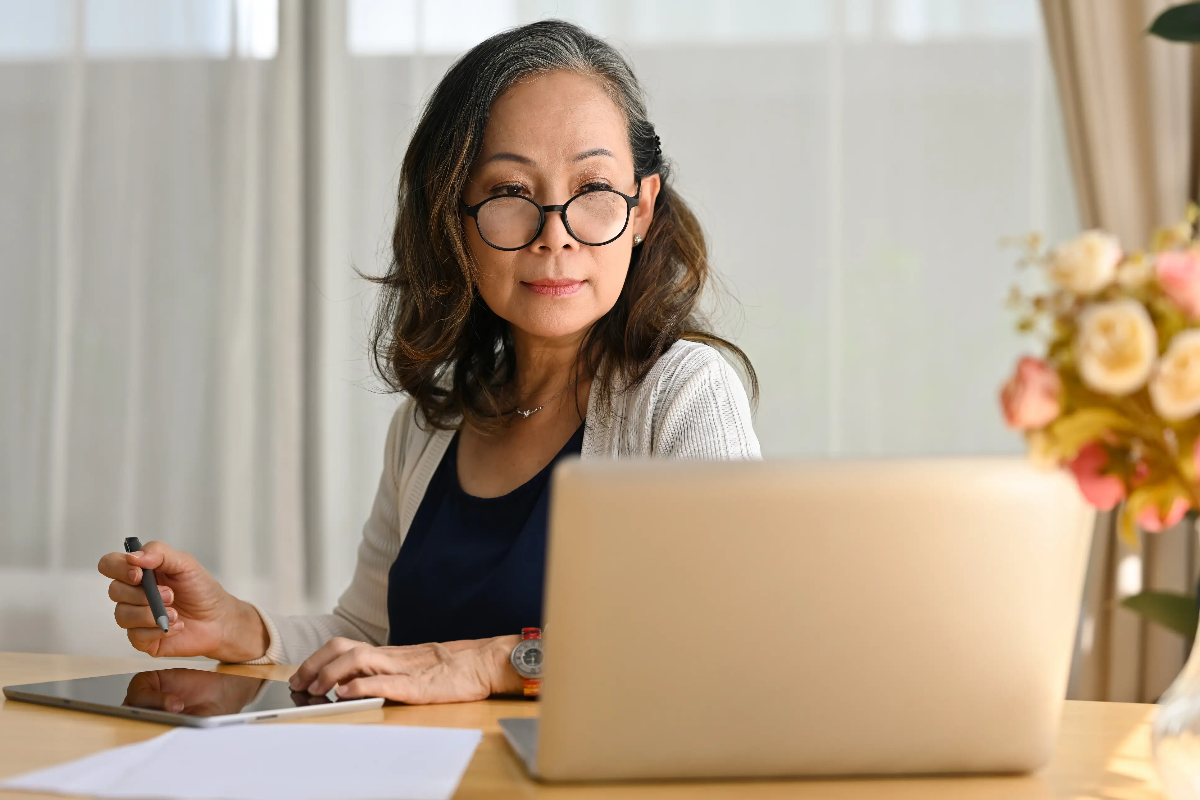 a woman sitting at a table with a laptop