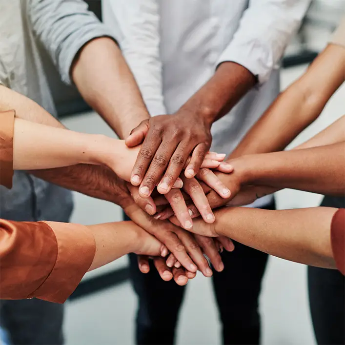 a group of people putting their hands together