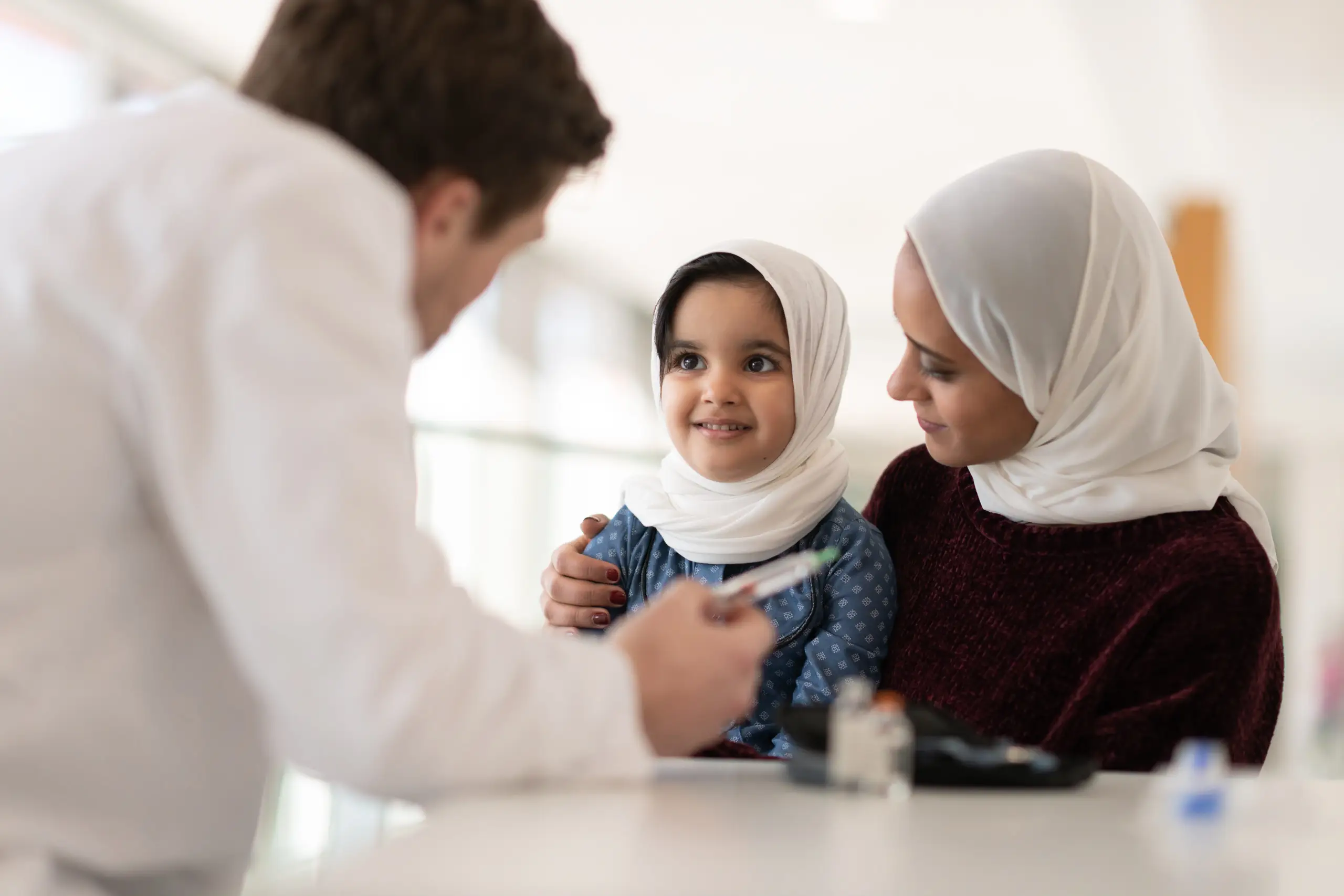 a woman and a child looking at a doctor
