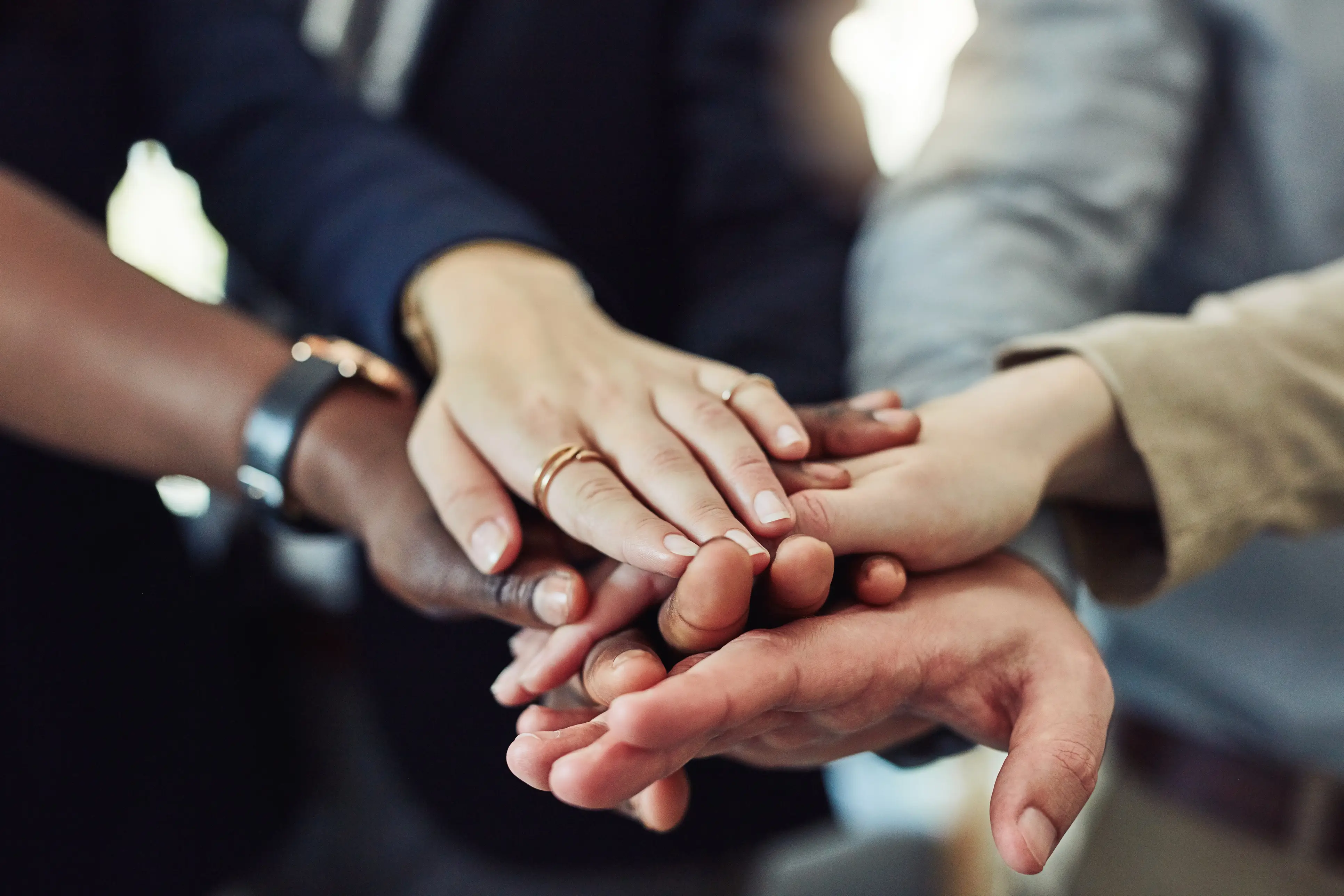 a group of people putting their hands together