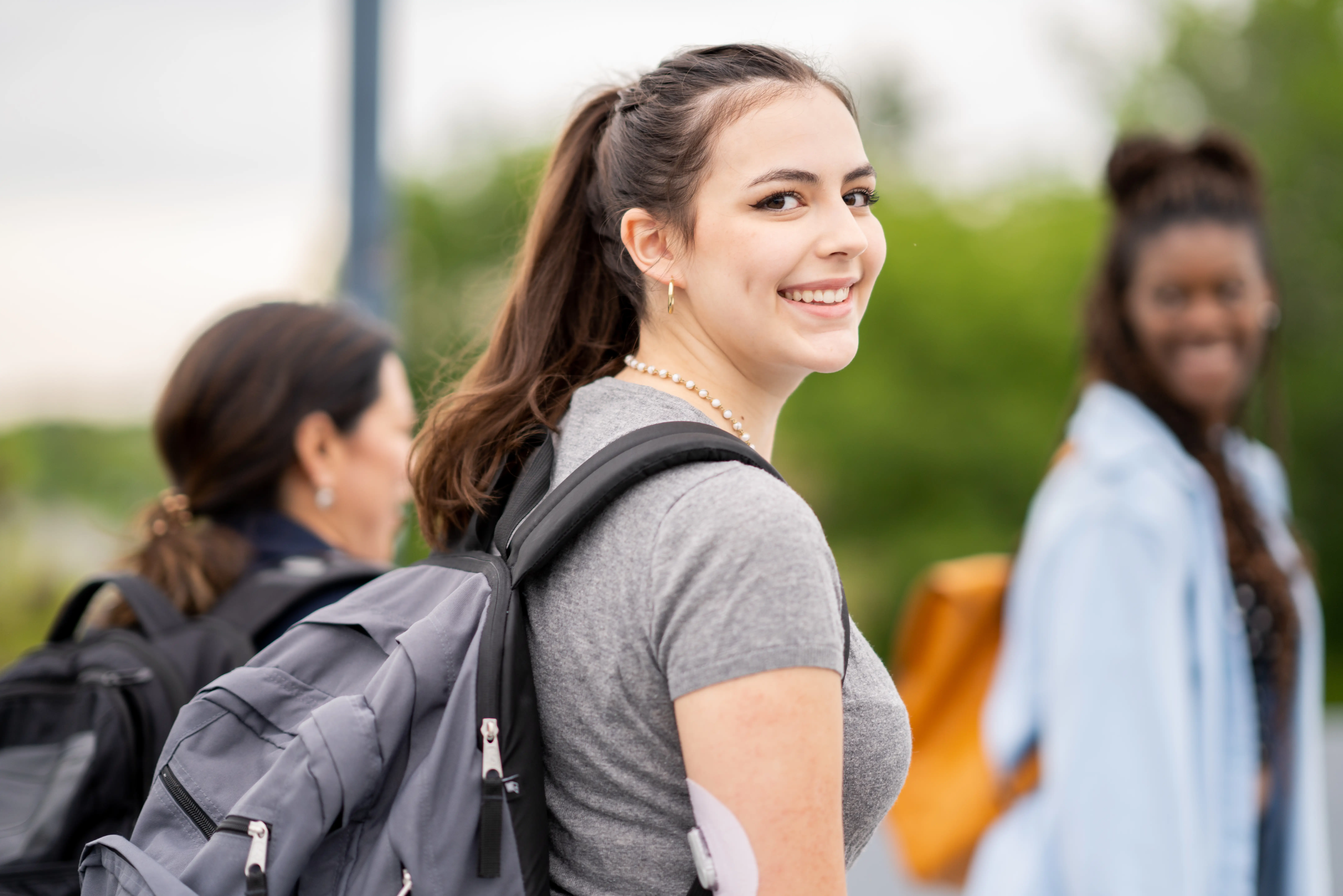 a woman smiling with a backpack