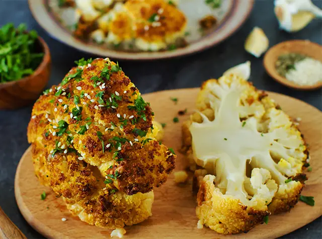 a plate of cauliflower with a piece of cooked cauliflower