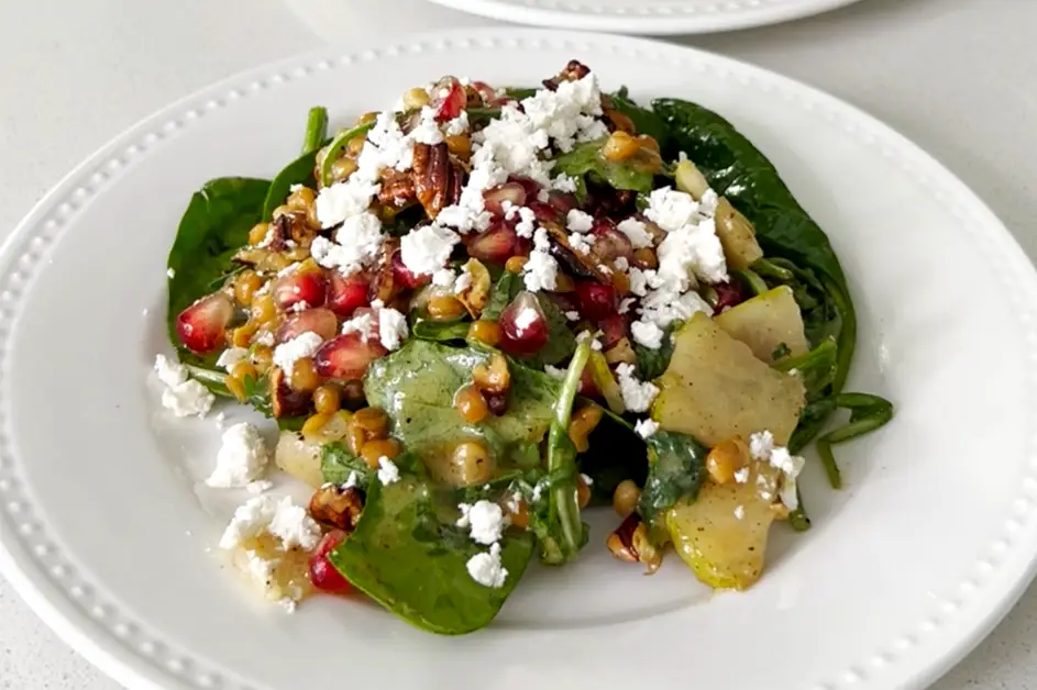 a plate of salad with cheese and nuts