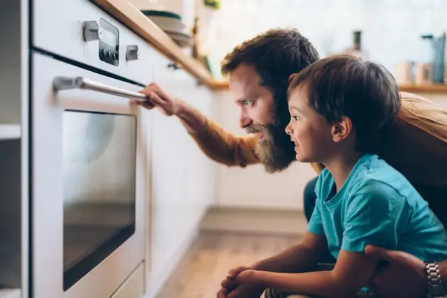 father-and-son-cooking-dinner-at-home-picture-id1203794009