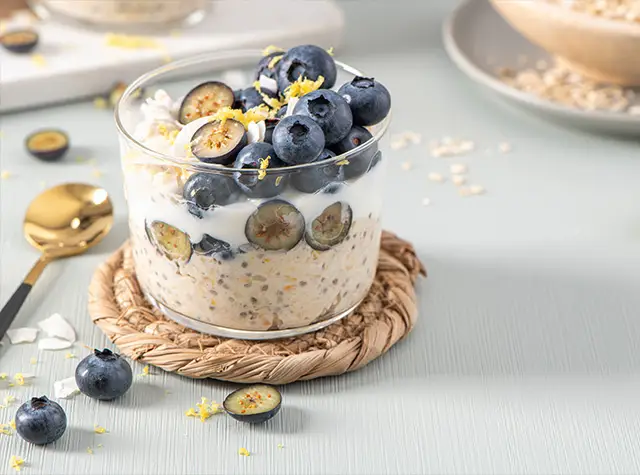 a glass of oatmeal with blueberries and yogurt